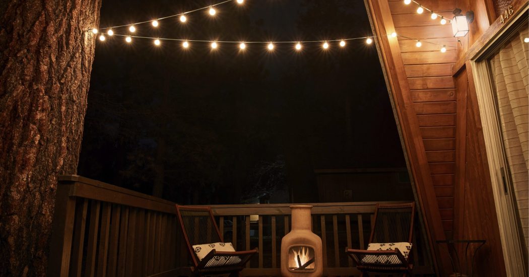 Fireplace and two wicker chairs on verandah of house