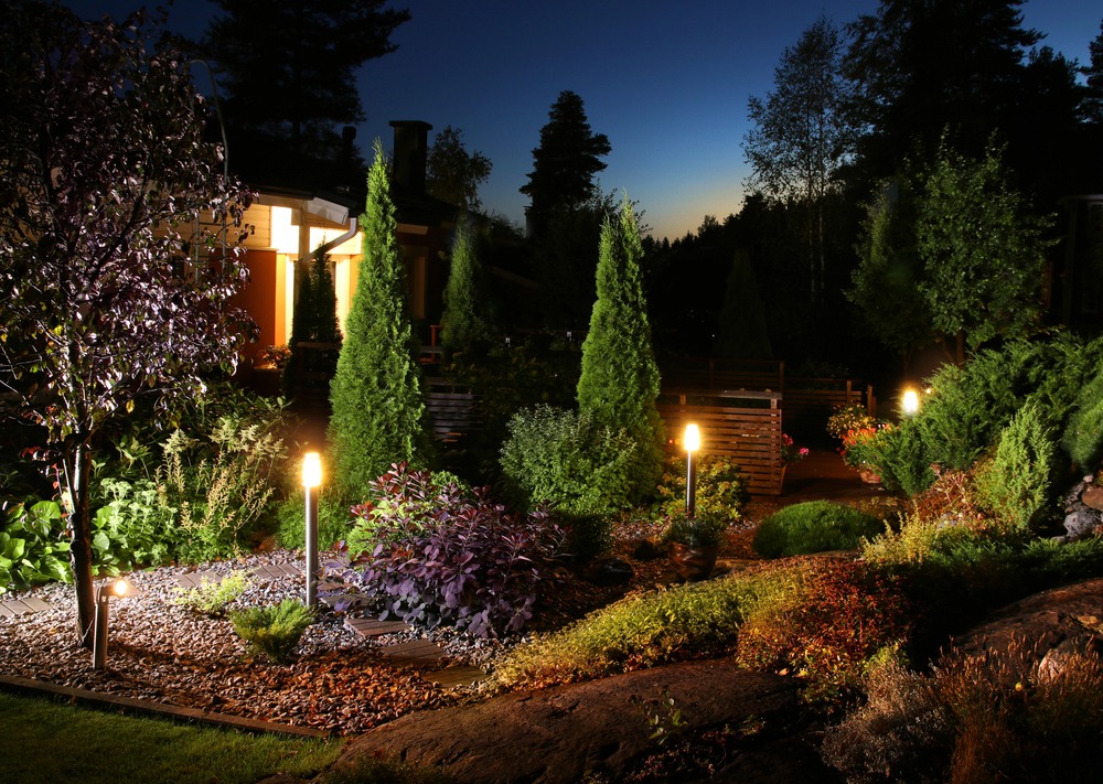 Lit bollard path lights along a garden walk at dusk