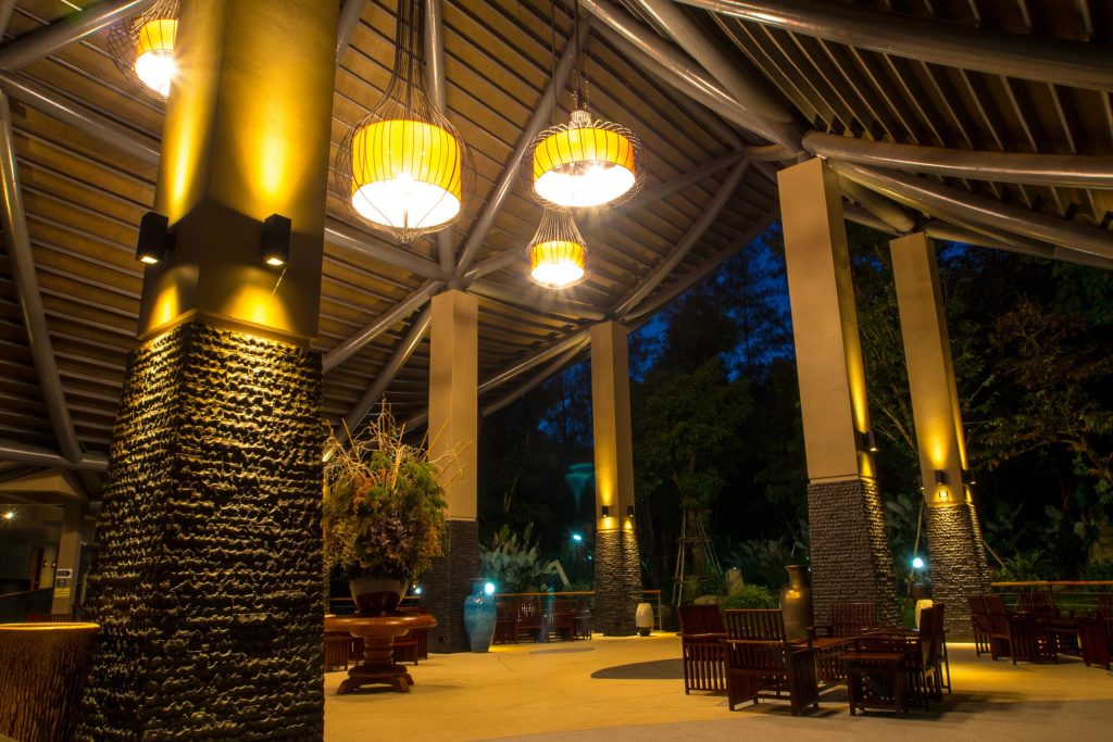 Outdoor pavilion lit by column and pendant lights at night