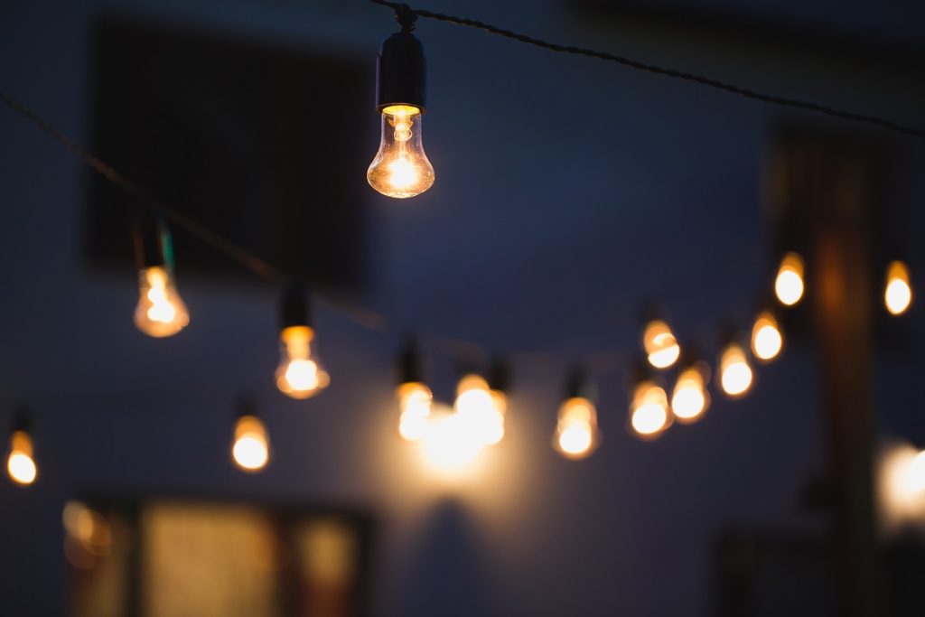 String lights hanging over a backyard at night